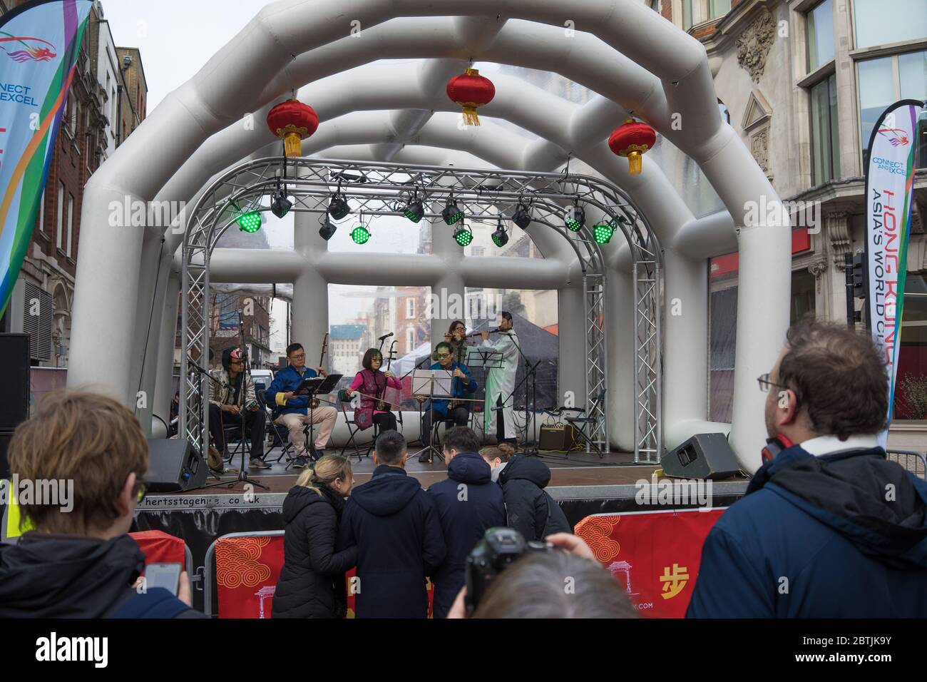 Band spielt Instrumente auf einer kleinen Bühne mit Touristen beobachten. Chinesische Neujahrsfeier. London Stockfoto