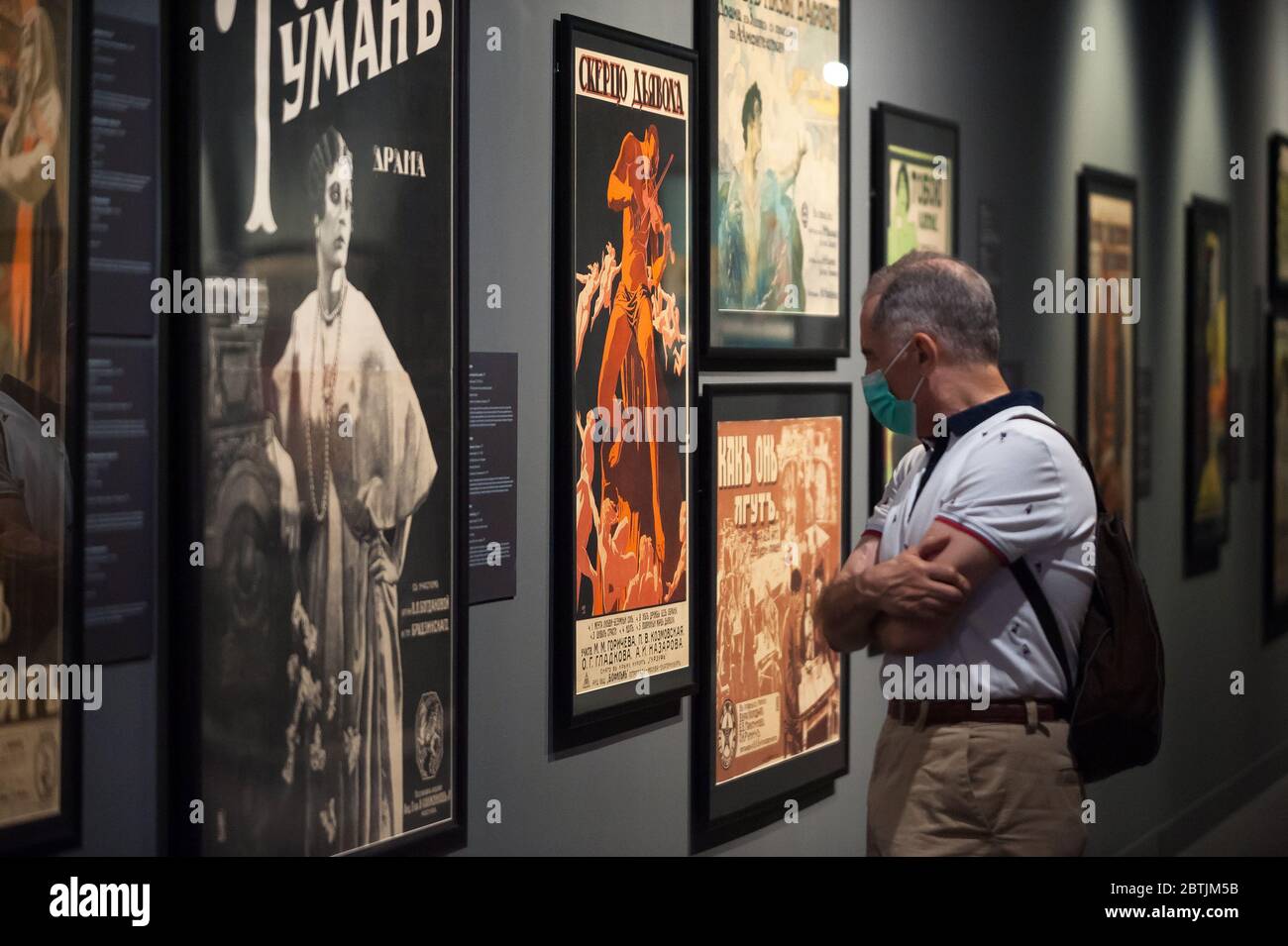 Ein Besucher, der eine Gesichtsmaske trägt, wirft einen genaueren Blick auf eines der Gemälde in der Ausstellung "Breaking the silence. Der Stummfilm in Russland" während Phase 1 in einem russischen Museum von Sankt Petersburg.Spanien durchläuft einen Plan der Abseilung in Richtung einer "neuen Normalität" durch lockende Maßnahmen des COVID-19 Ausbruchs. Mehrere wichtige Museen der Stadt Málaga haben nach dem Beginn des Notstandes wieder eröffnet und garantieren Sicherheitsmaßnahmen wie Gesichtsmasken, Desinfektionsmittel, Temperaturscans am Eingang der Museen. Stockfoto