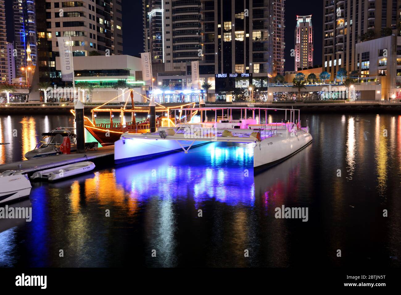 DUBAI, VAE - NOVEMBER 15: Die Nachtbeleuchtung von Dubai Marina und Katamaran und traditionelle Dhow Boot, am 15. November 2019 in Dubai, VAE Stockfoto