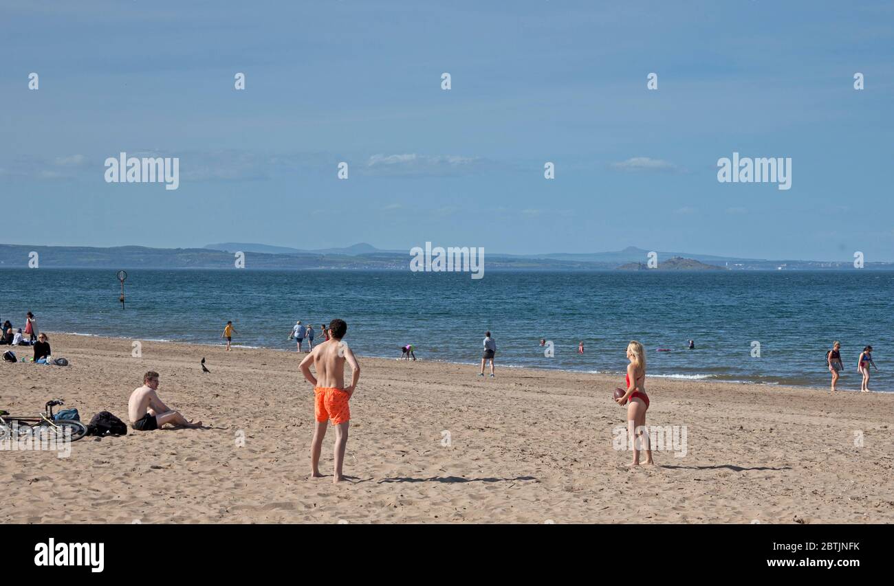 Portobello, Edinburgh, Schottland, Großbritannien. 26 Mai 2020. Entspannte Atmosphäre am Meer am späten Nachmittag, als Schottland dem Ende der Phase 1 der Coronavirus-Lockdown nähert. Temperatur von 19 Grad und sonnig. Die Leute genießen es, am Sandstrand herum zu sitzen, ohne dass man sich Sorgen macht, weiter gezogen zu werden. Stockfoto