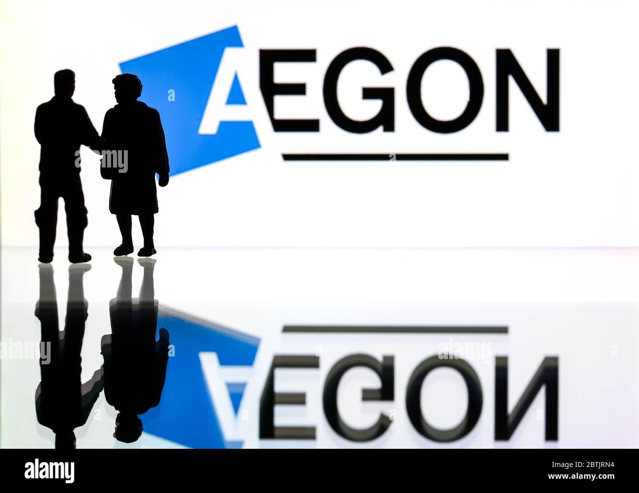 Silhouetten vor dem Logo für Aegon, einen Finanzdienstleister. (Nur redaktionelle Verwendung) Stockfoto