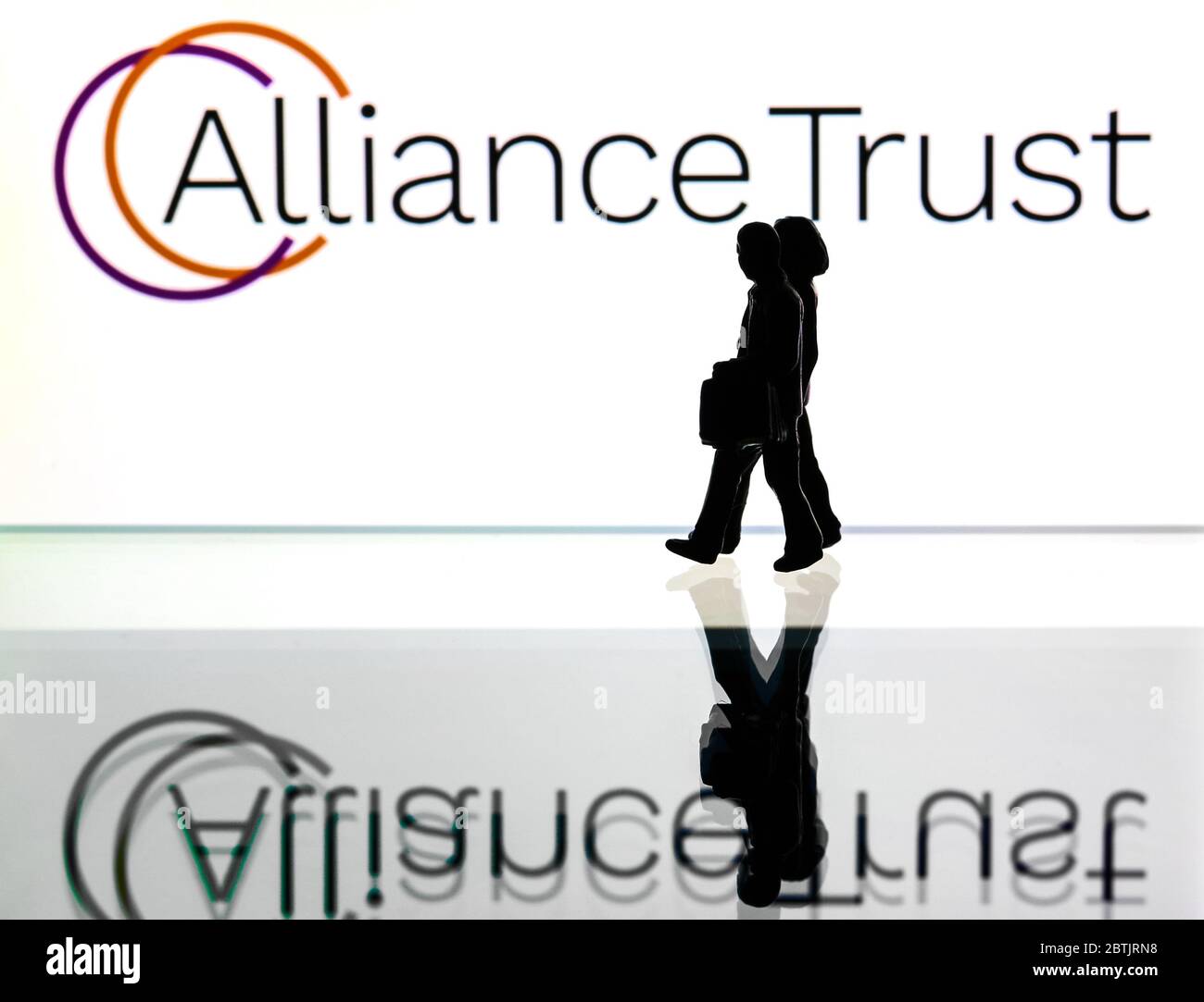 Silhouetten vor dem Logo für Alliance Trust PLC. (Nur redaktionelle Verwendung) Stockfoto