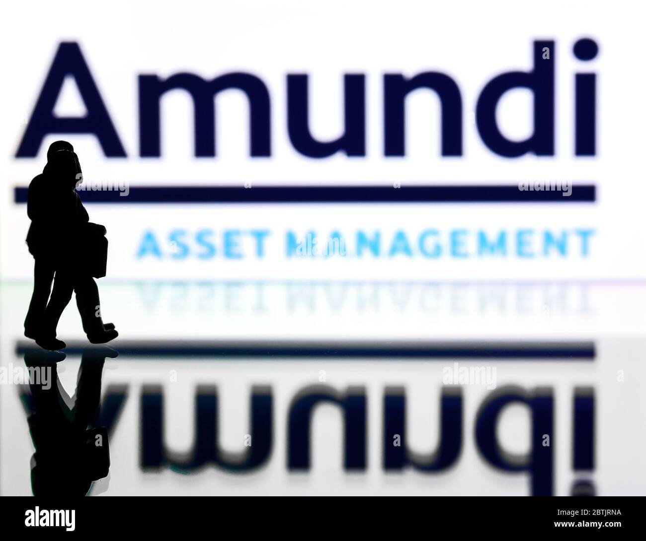 Silhouetten vor dem Logo für Amundi Asset Management. (Nur redaktionelle Verwendung) Stockfoto
