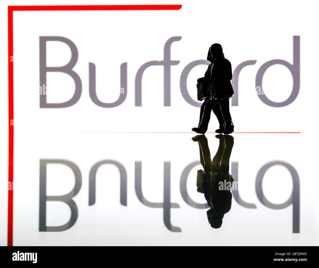 Silhouetten vor dem Logo für Burford Capital. (Nur redaktionelle Verwendung) Stockfoto