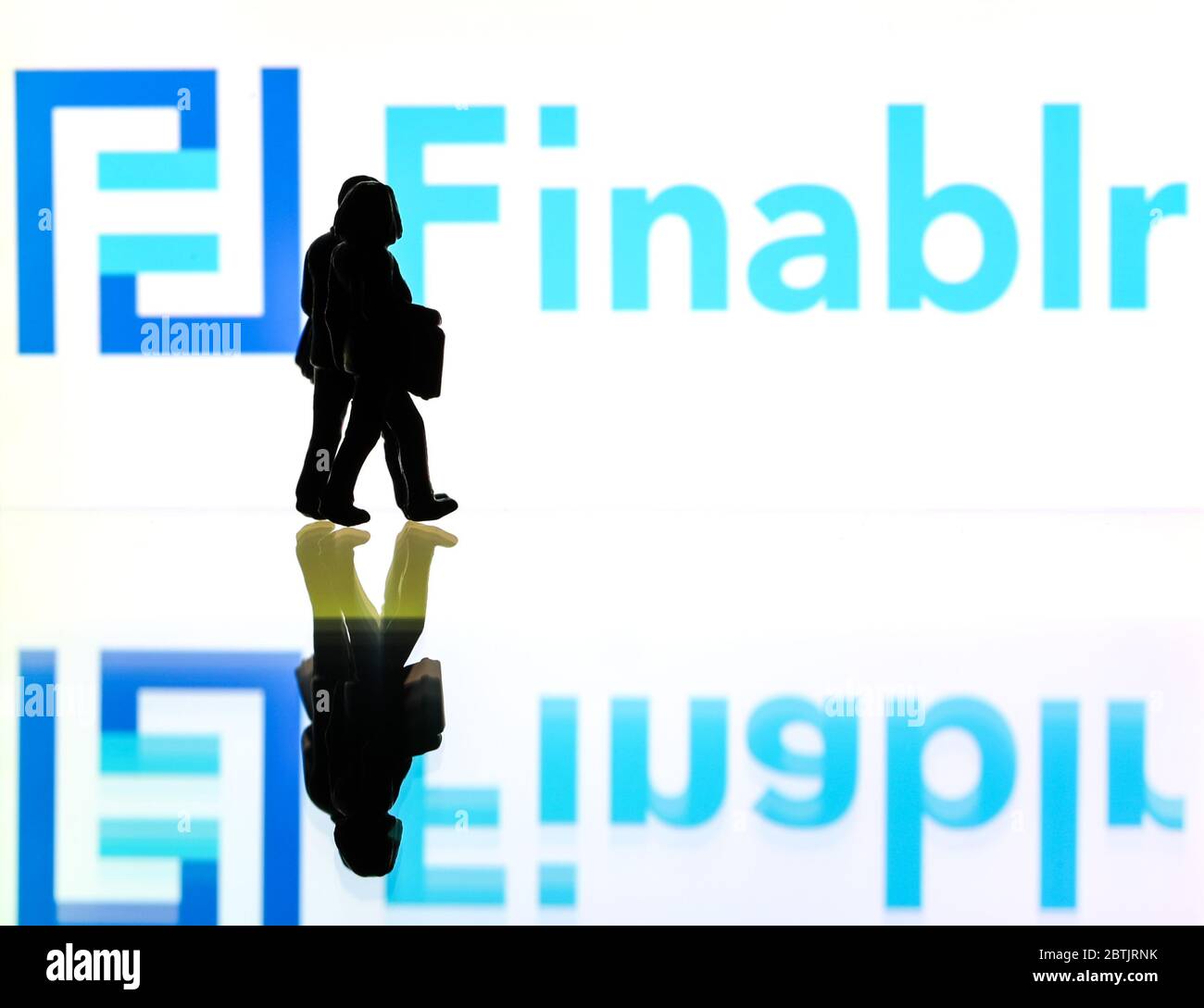 Silhouetten vor dem Logo für Finable, ein Finanzdienstleister. (Nur redaktionelle Verwendung) Stockfoto