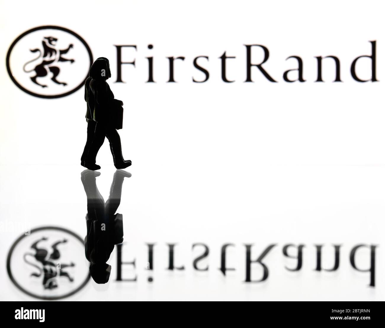 Silhouetten vor dem Logo der FirstRand Group. (Nur redaktionelle Verwendung) Stockfoto