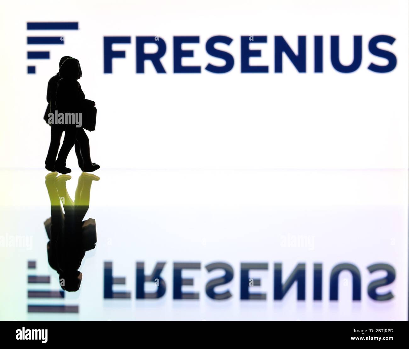 Silhouetten vor dem Logo für Fresenius ein medizinisches Pflegeunternehmen. (Nur redaktionelle Verwendung) Stockfoto