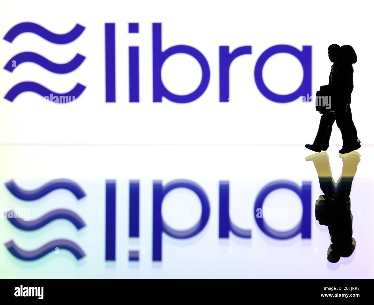 Silhouetten vor dem Logo für Libra eine digitale Blockchain-Währung von Facebook (nur redaktionelle Verwendung) Stockfoto