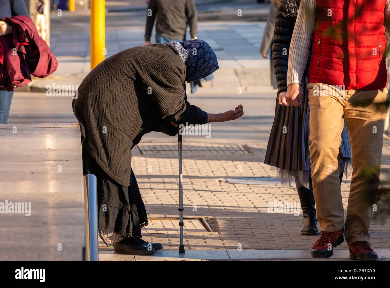 Ältere Bettlerin, die schwarze Kleidung trägt und einen Stock hält und in Sofia, Bulgarien, Osteuropa, Balkan und der EU um Geld bettelt Stockfoto
