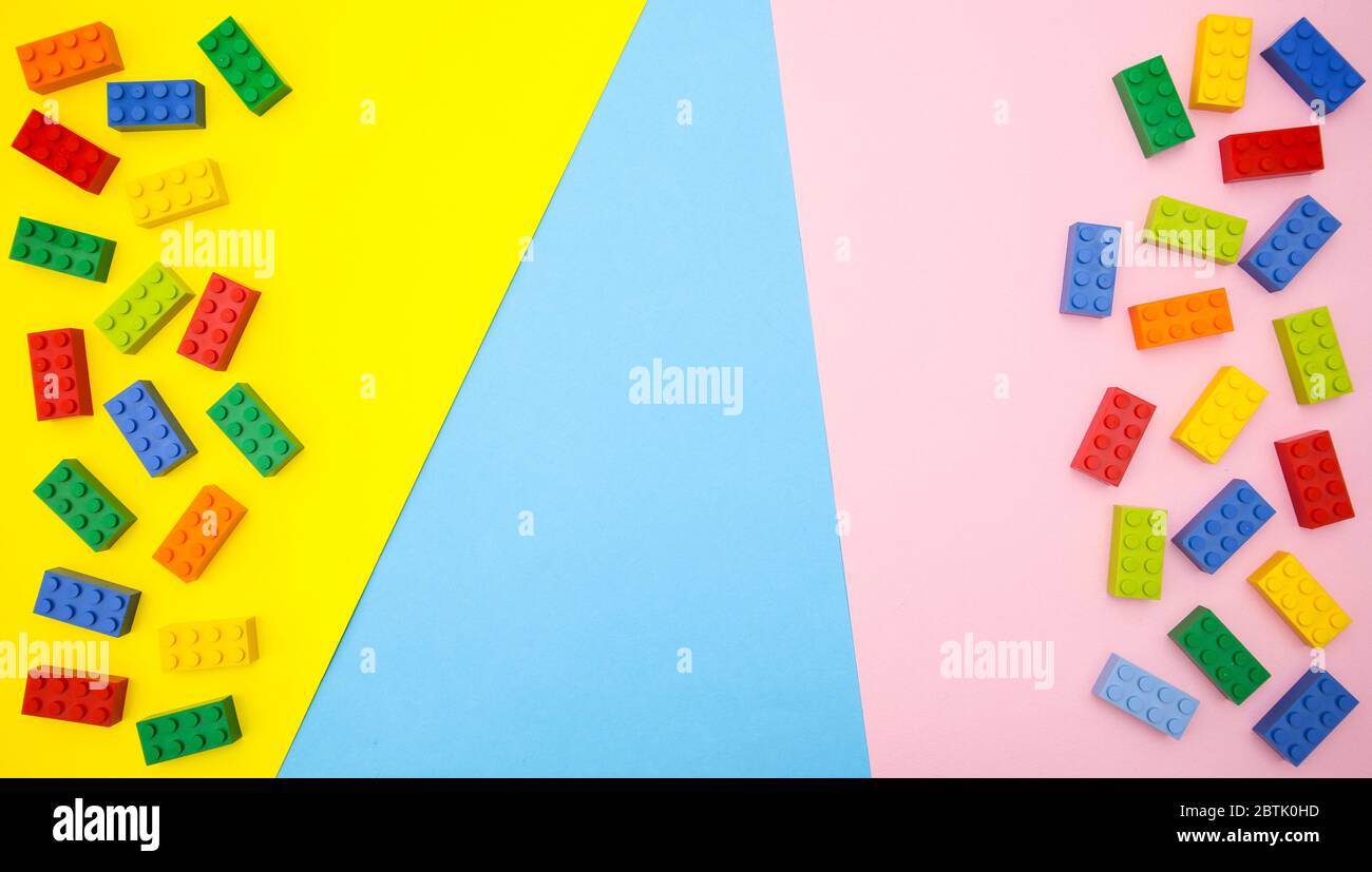 Bunte Spielzeuge für Kinder auf blauem gelbem Hintergrund Stockfoto