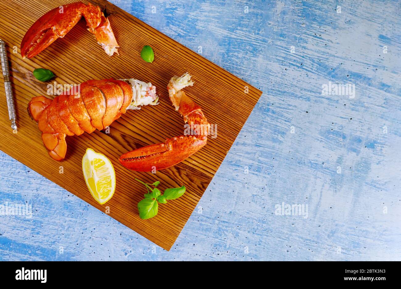 Hummerschwänze Krallen auf dem Schneidebrett, bereit, auf dem Tisch mit Zitrone zu essen Stockfoto
