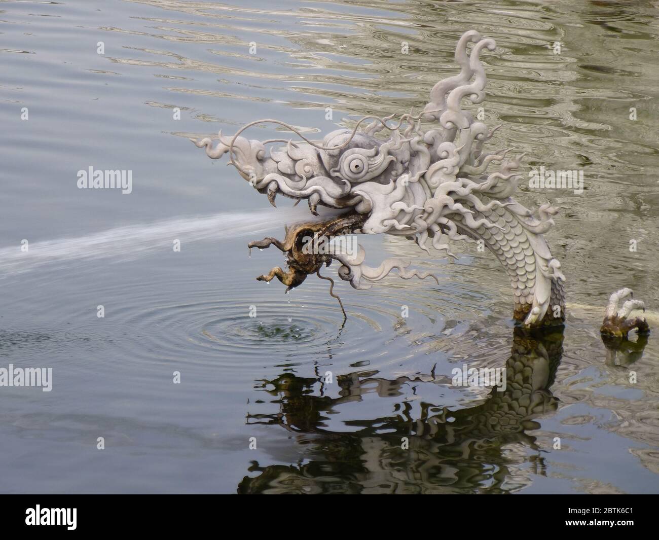 Der kleine Drache spuckt Wasser im kleinen Ententeich vor dem Wat Rong Khun, dem schönen weißen Tempel in Chiang Rai Stockfoto