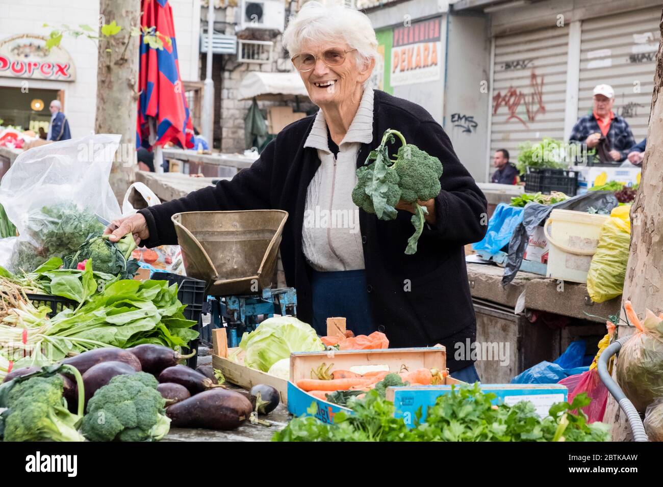 Ältere weibliche Obst- und Gemüsehändler lächelt auf dem Grünen Markt von Split, direkt vor dem Diokletianpalast, Altstadt, Split, Kroatien Stockfoto