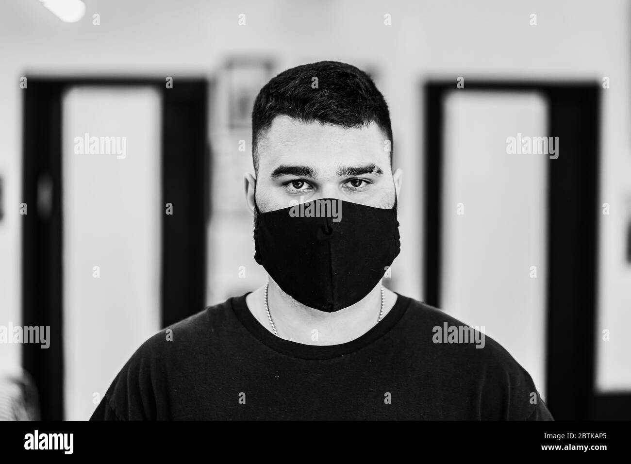 Männliches schwarz-weißes Porträt. Ein Mann in einer schwarzen Maske. Stockfoto