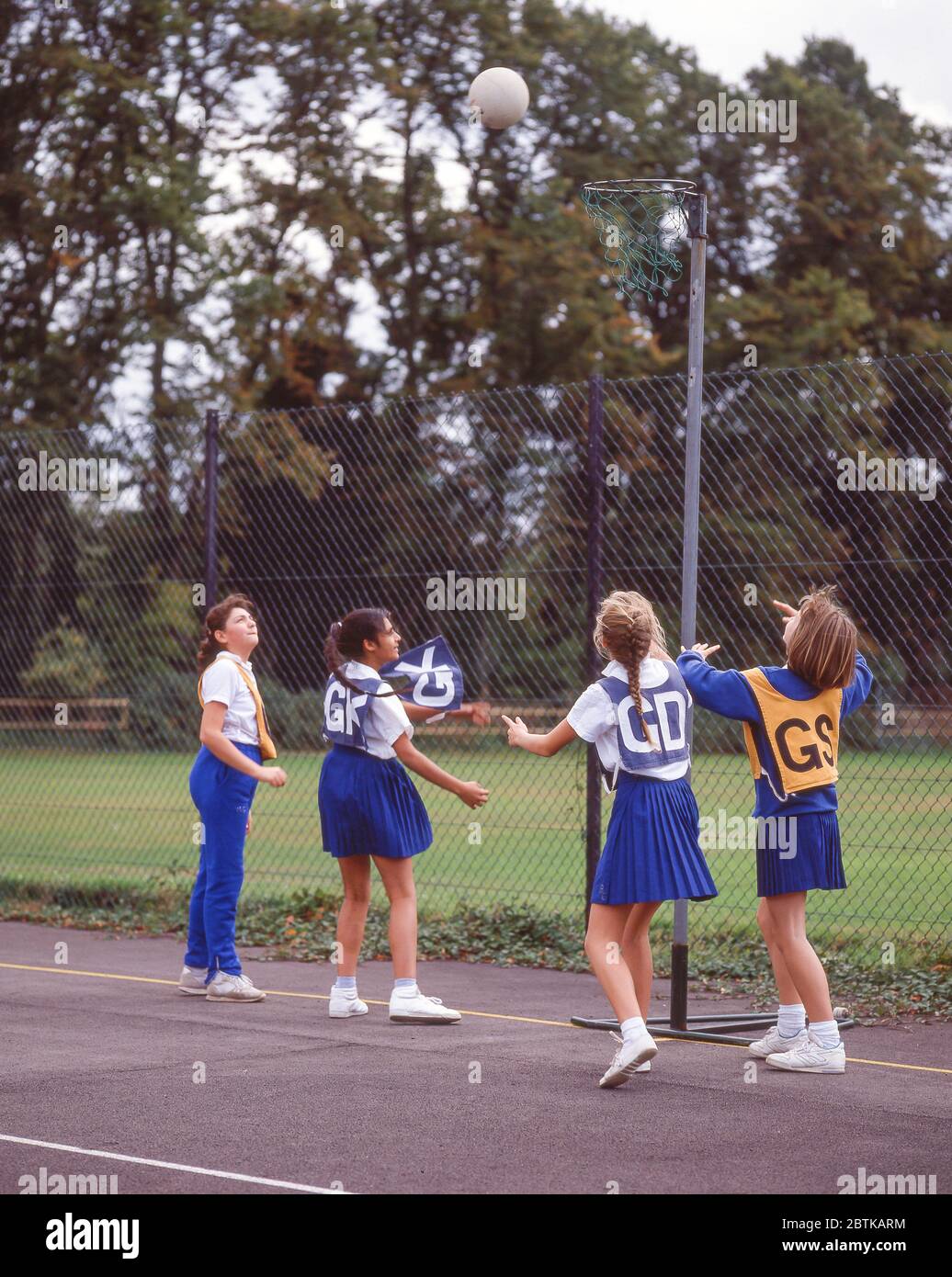 Schülerinnen, die auf den Schulplätzen Netball spielen, Surrey, England, Großbritannien Stockfoto