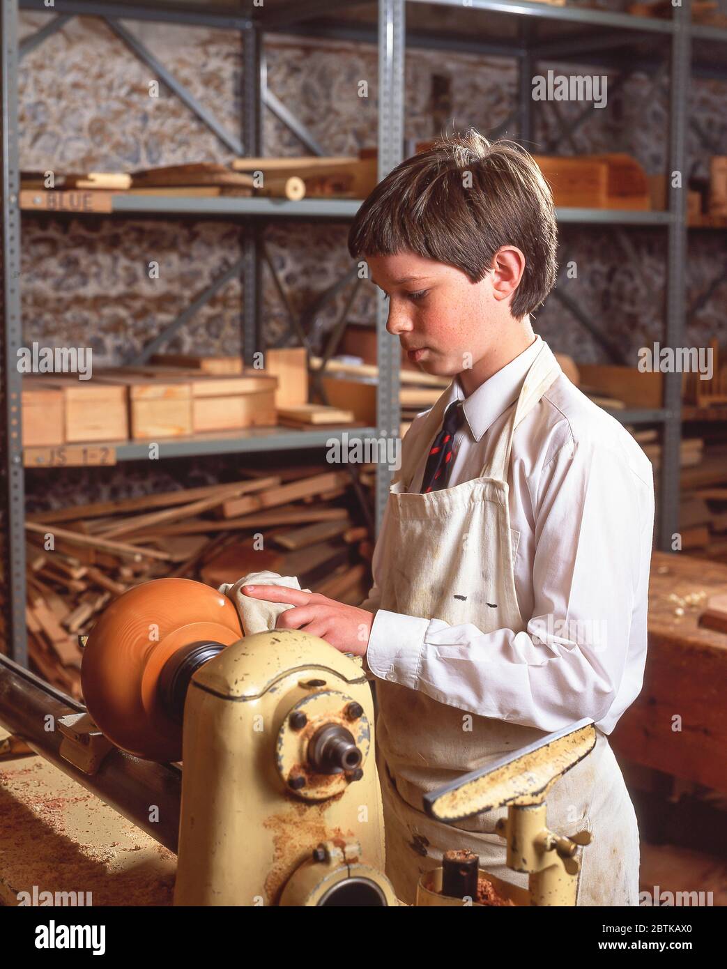 Junger Junge mit Drehmaschine in der Holzarbeits-Klasse, Surrey, England, Großbritannien Stockfoto