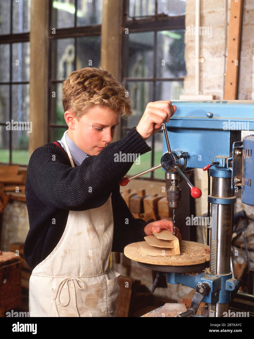 Junger Junge mit Bohrer in der Holzarbeits-Klasse, Surrey, England, Großbritannien Stockfoto