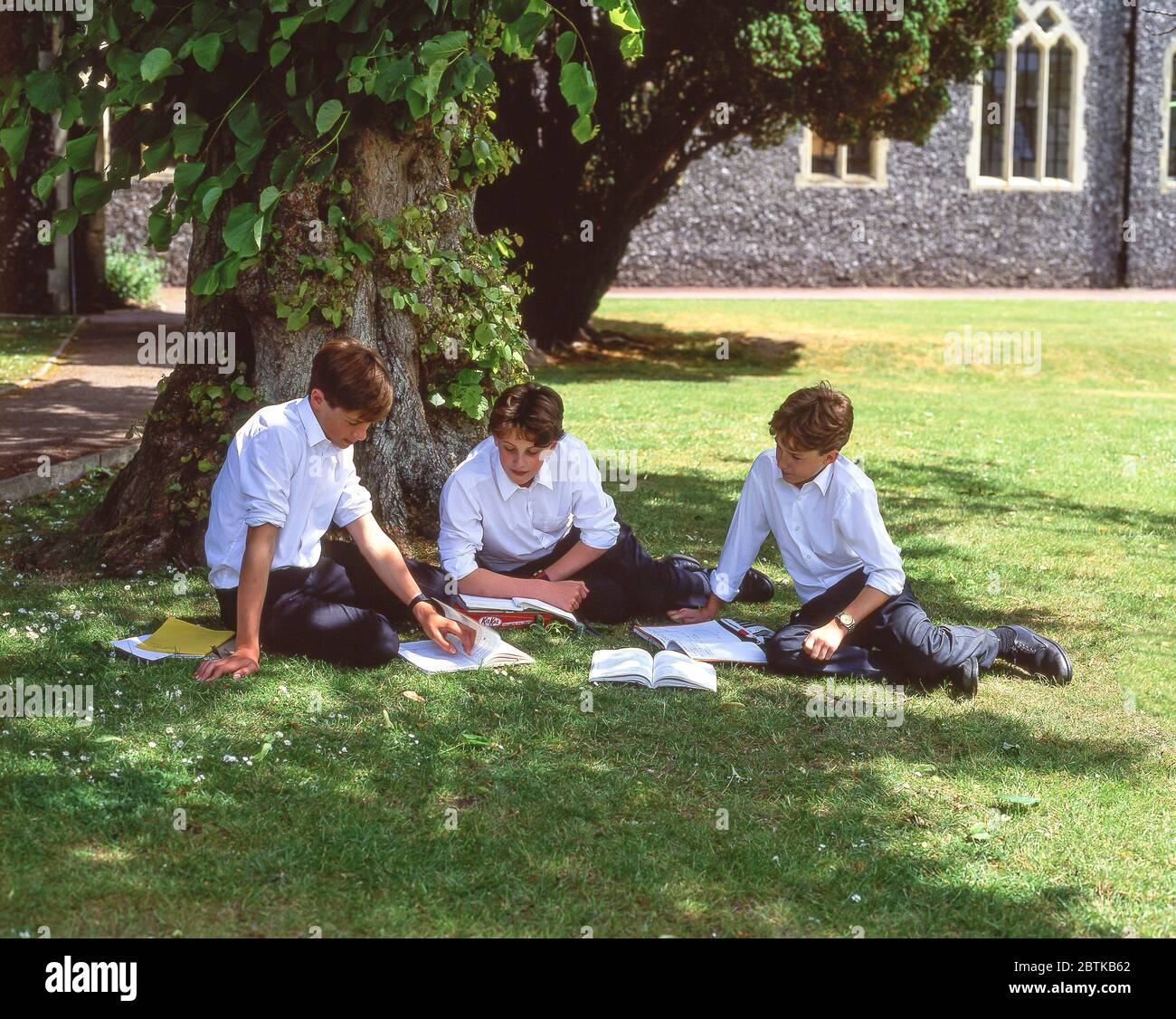 Schüler entspannen und lesen auf dem Schulgelände, Surrey, England, Großbritannien Stockfoto