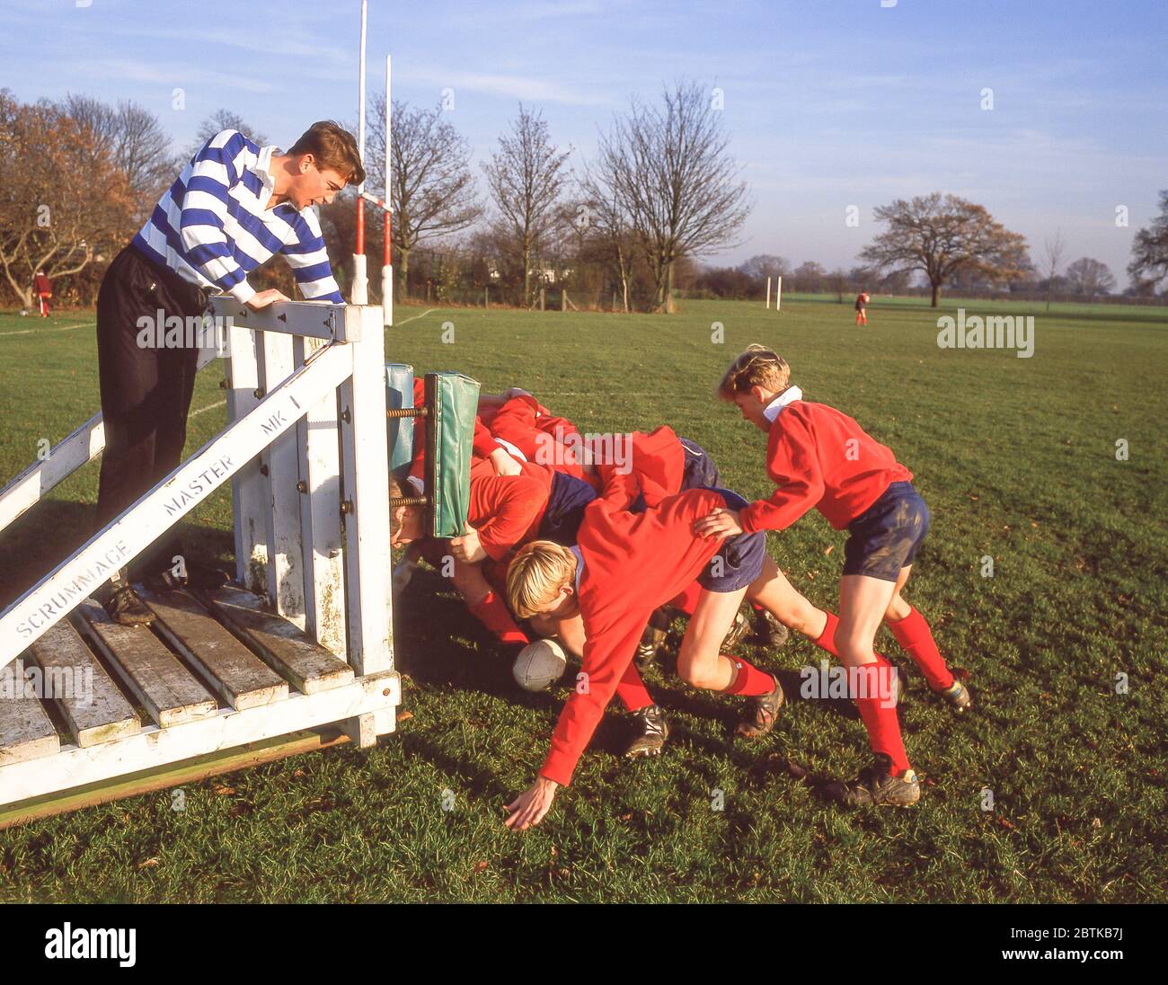 Jungs kratzen gegen Scrum-Maschine bei Schule Rugby Spiel, Surrey, England, Vereinigtes Königreich Stockfoto