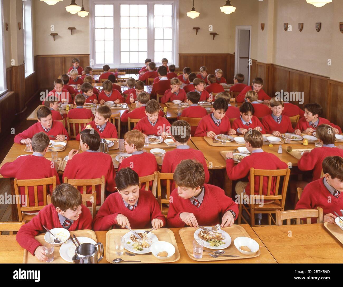 Schulkinder essen Mittagessen in der Schule Speisesaal, Surrey, England, Großbritannien Stockfoto