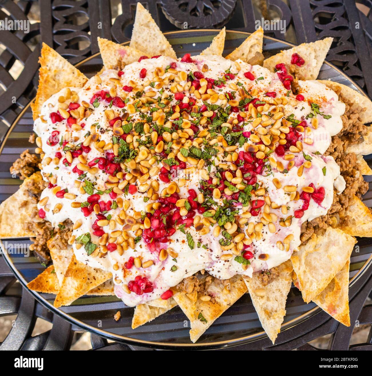 Ein Teller mit Rindfleisch und Aubergine farteh, ein traditionelles mittelöstliches Gericht mit gerösteten Stücken Fladenbrot, gekrönt mit fleischiger Aubergine und Rindfleisch und Joghurt Stockfoto