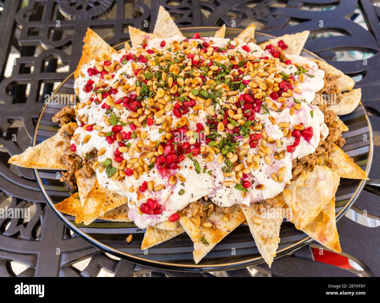 Ein Teller mit Rindfleisch und Aubergine farteh, ein traditionelles mittelöstliches Gericht mit gerösteten Stücken Fladenbrot, gekrönt mit fleischiger Aubergine und Rindfleisch und Joghurt Stockfoto