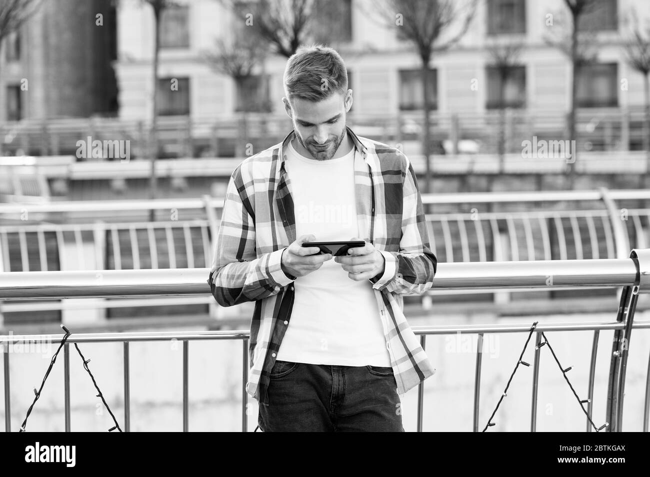 Kommunikation. E-Mail senden. Nachricht wird beantwortet. Urbanes wifi. Smartphone-Einstellungen. Standortoptionen für die gemeinsame Nutzung. Anwendung. Mann hält Smartphone-Gebäude im Hintergrund. Online-Messaging. Modernes Smartphone. Stockfoto