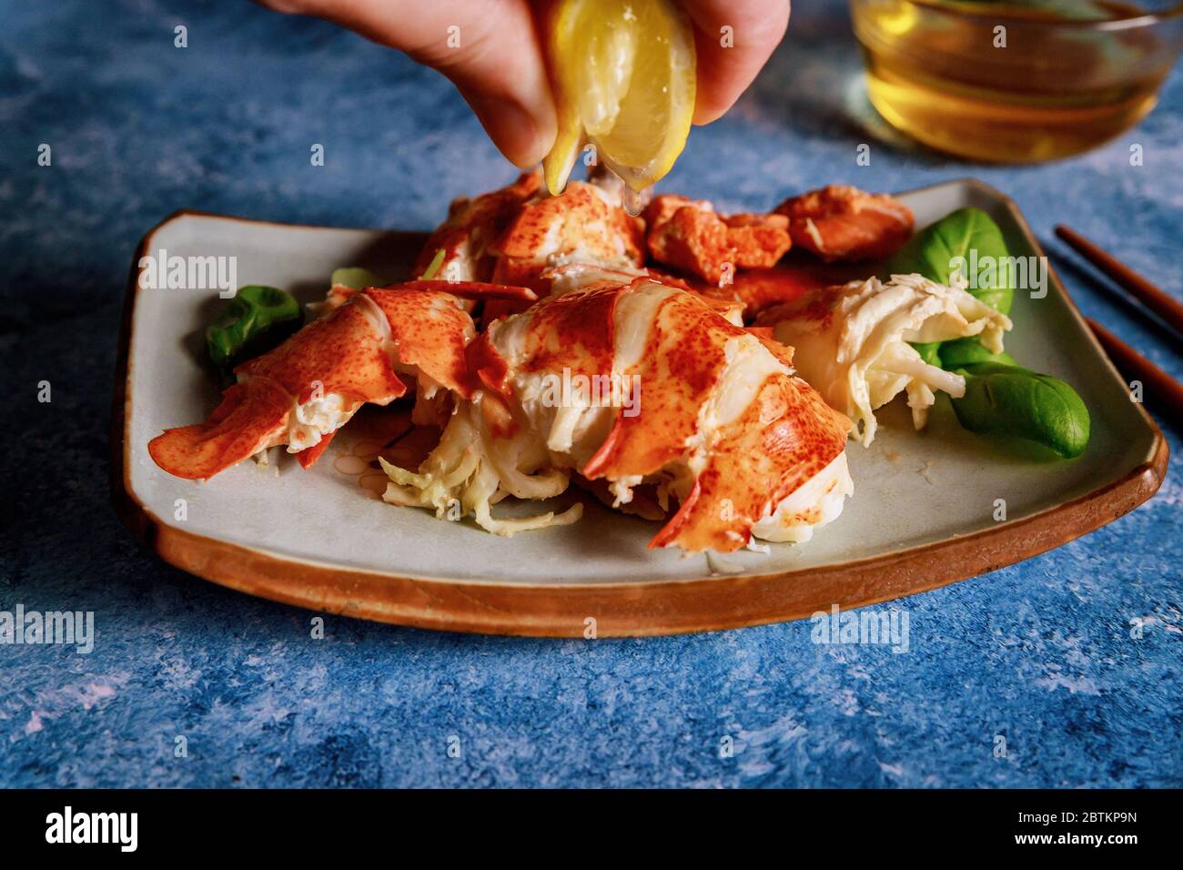 Abendessen mit gekochten, fertig zu essen Hummer Stücke in den Tisch mit Zitrone und Butter Sauce Stockfoto