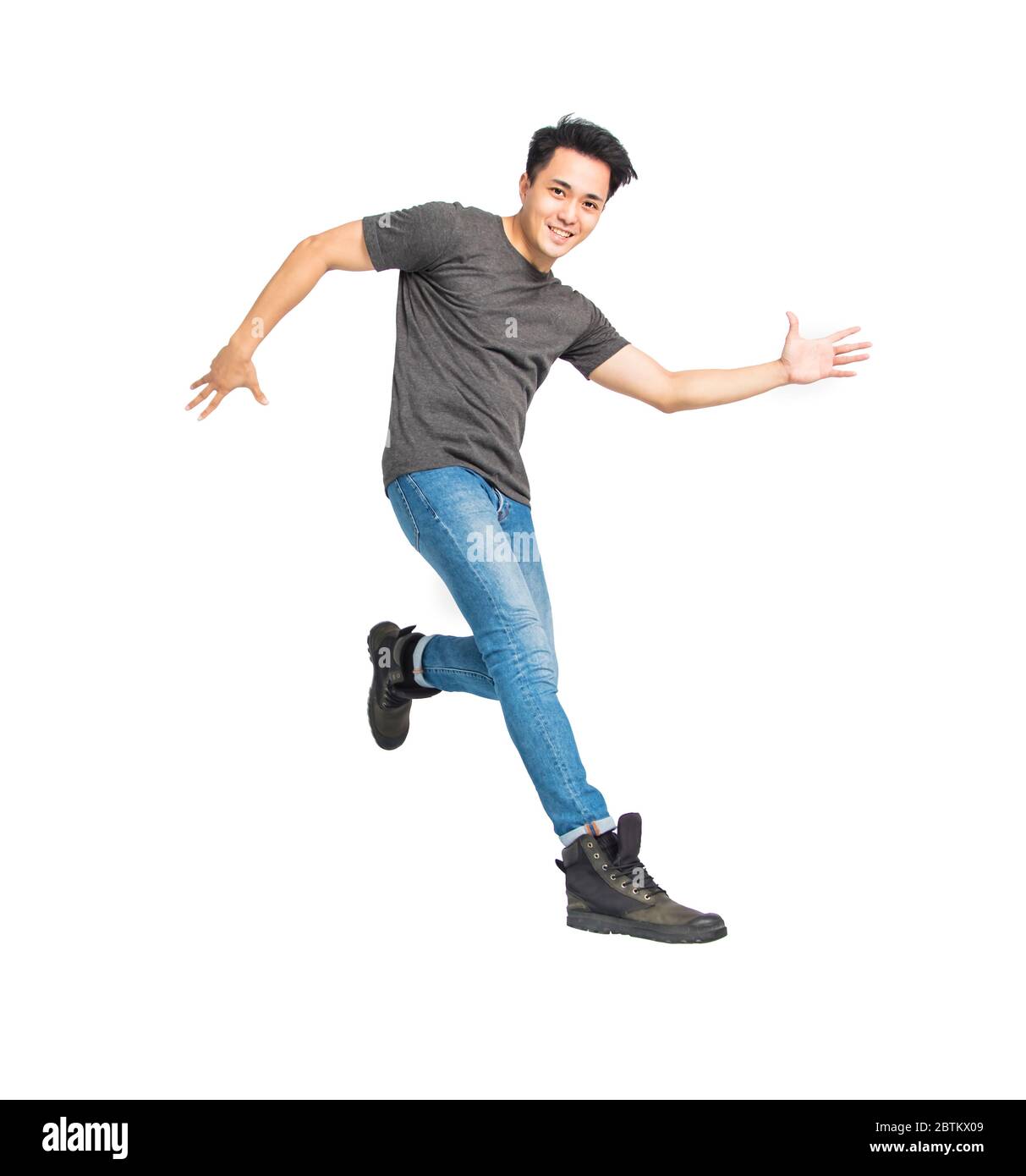Glücklich junge asiatische Mann tanzen und springen isoliert auf weiß Stockfoto