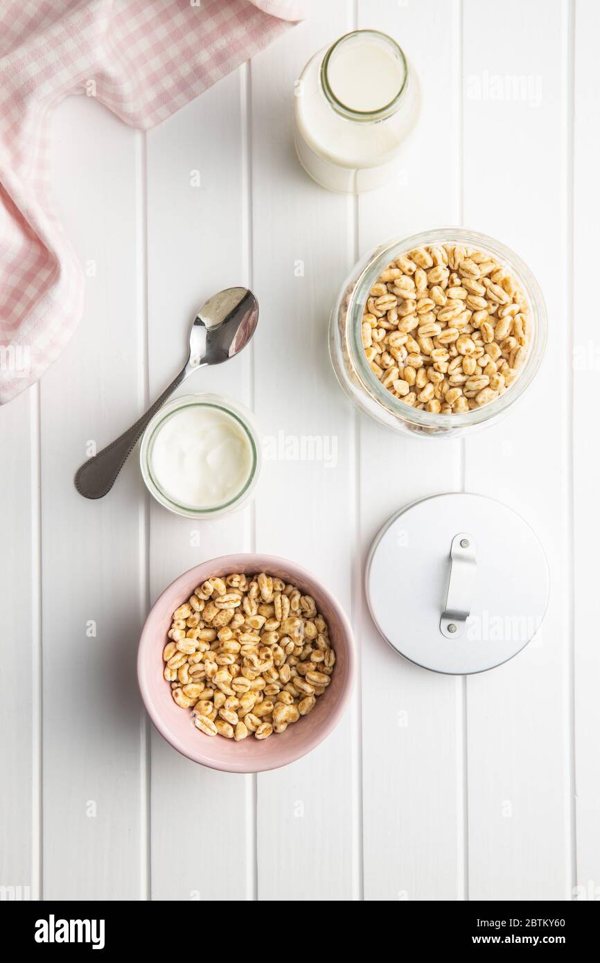 Mit Honig und Milch überzogene, gepuffte Weizensorte. Frühstück mit Cerealien. Draufsicht. Stockfoto