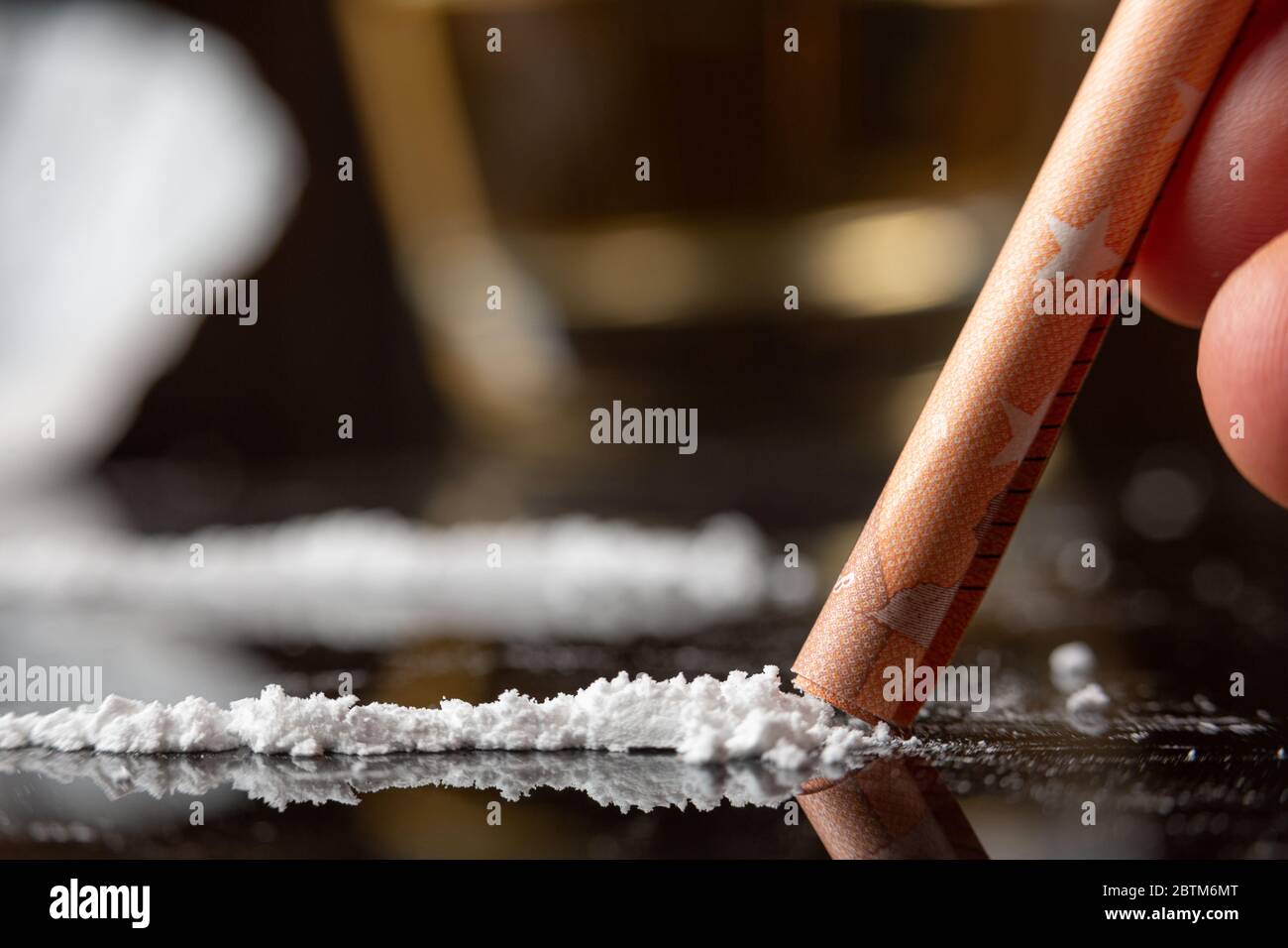 Kokainlinie, die von einem Mann mit einem gerollten Schnabel schnaubte. Nahaufnahme, Makroaufnahme Stockfoto