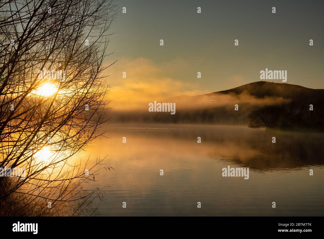 Ein dramatischer Sonnenaufgang mit geringer Wolke und Nebel über dem kleinen See in Twizel Neuseeland Stockfoto