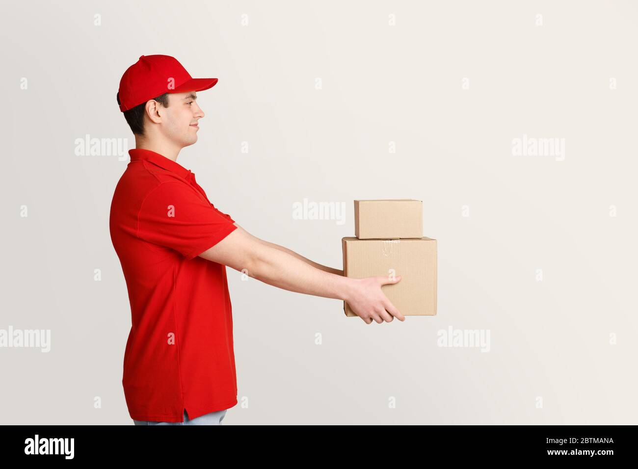 E-Commerce-Käufe werden direkt vor die Tür geliefert. Kurier hält Kisten in Händen Stockfoto