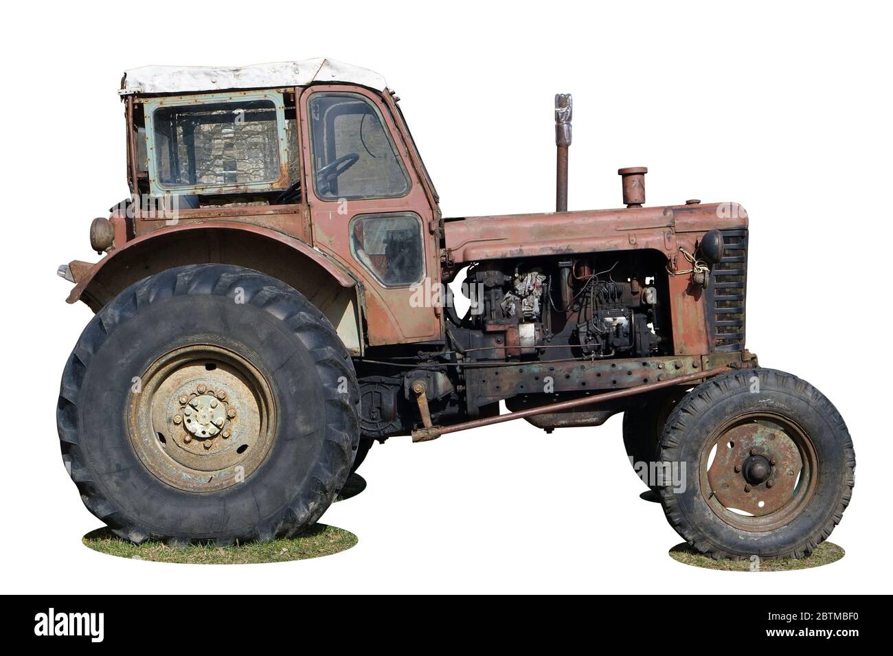 Rostige Seitenansicht Räder eines Vintage-Räder Bauer kein Name Traktor . Isoliert auf weißem Nahaufnahme Stockfoto