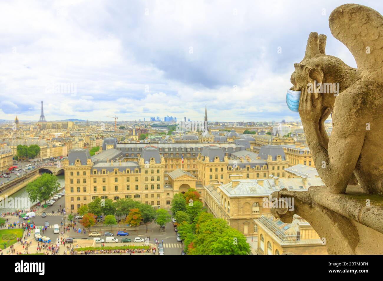 Gargoyle mit chirurgischer Maske in Paris während der Covid-19 Pandemie. Französische Quarantäne für Coronavirus. Luftaufnahme von Paris von der Kathedrale Notre Dame Stockfoto