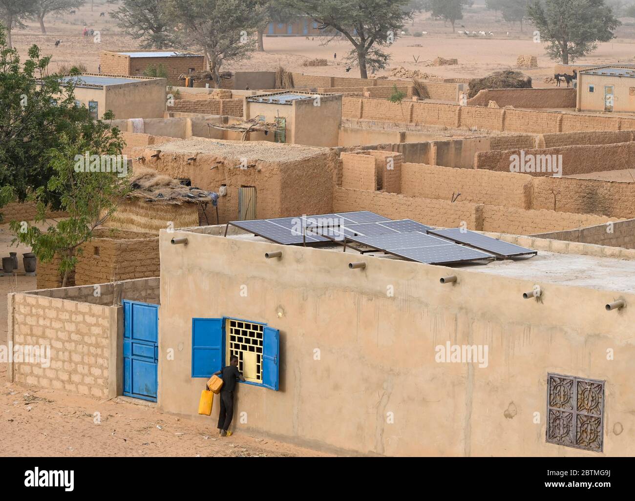 NIGER, Maradi, Dorf Dan Bako, Lehmhäuser und Zementbau mit Photovoltaik-Solaranlage / Haus aus Lehm und Zement mit Solar Home System Stockfoto
