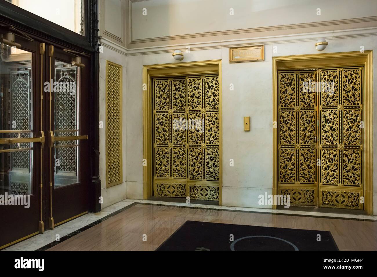 Horizontaler Blick auf zwei reich dekorierte goldene Aufzüge in der Fisher Building Lobby, 343 S. Dearborn St, Chicago, Illinois, USA Stockfoto