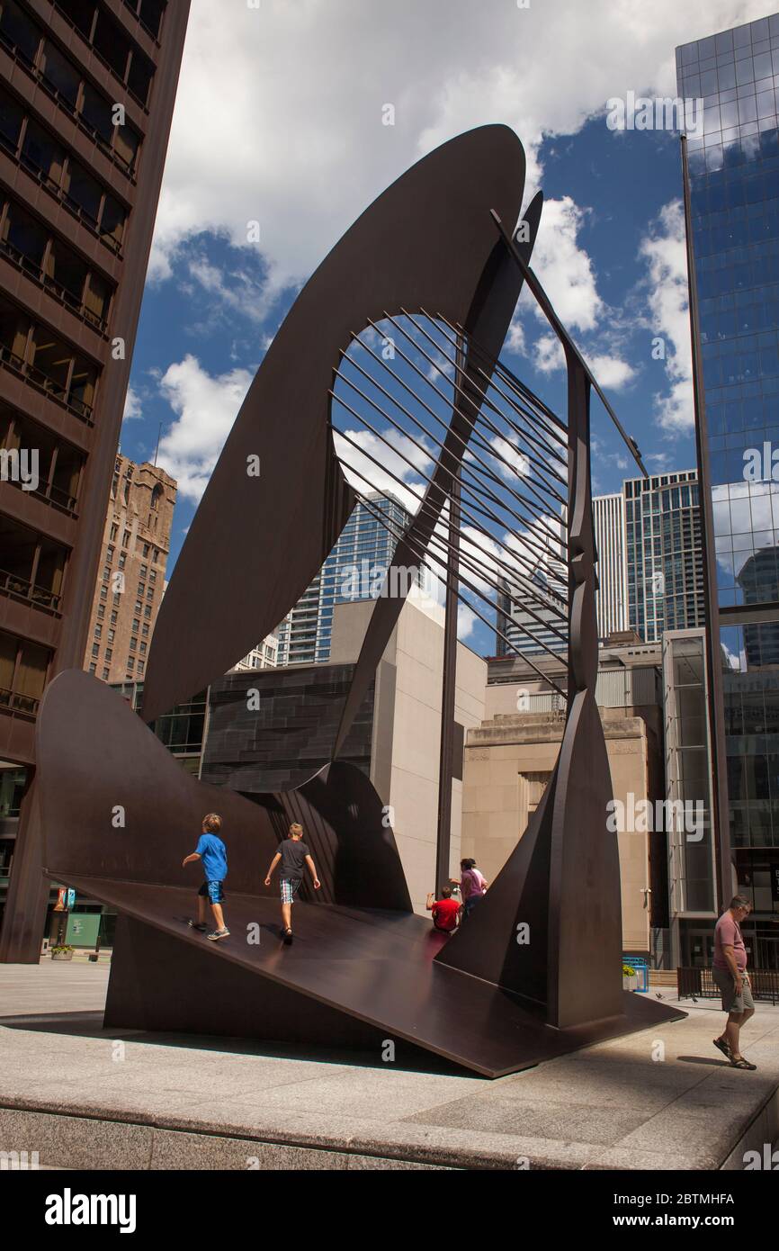 Vertikale Aufnahme von zwei Kindern, die über die Picasso-Skulptur ohne Titel auf dem Daley Plaza in Chicago Loop, Illinois, USA, gehen Stockfoto