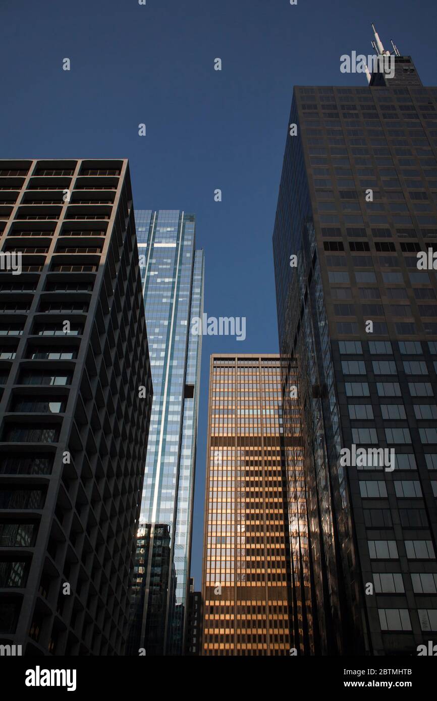 Vertikale Low-Angle-Aufnahme der façade des Willis Tower und anderer Wolkenkratzer am Chicago River mit einem wunderschönen Sonnenuntergang Licht, Chicago, Illinois Stockfoto
