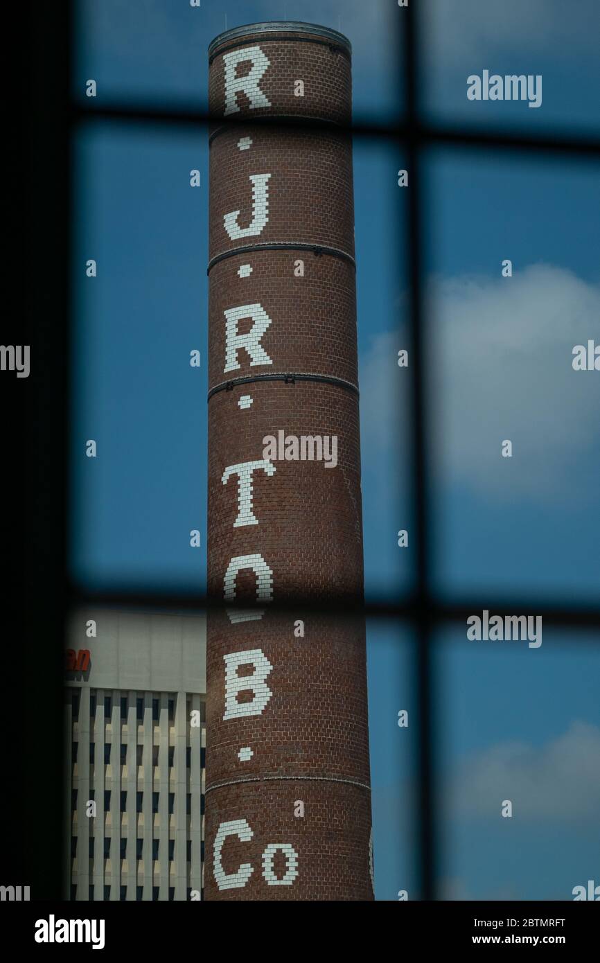 Smokestacj aus der alten R.J Reynolds Tabakfabrik im Vordergrund mit Winston Tower im Hintergrund - Winston Salem, North Carolina Stockfoto