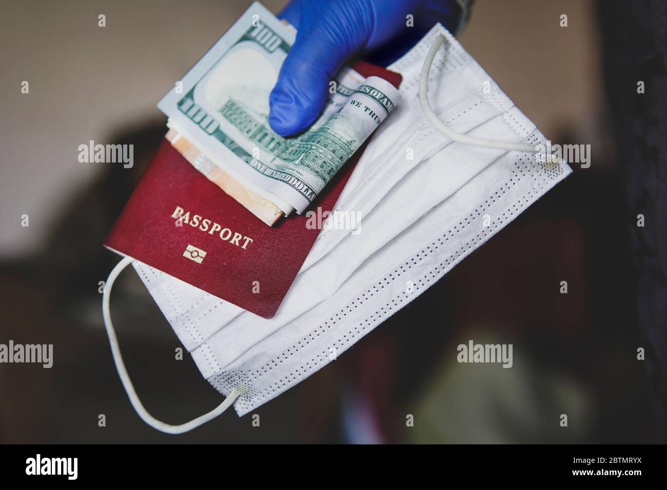 Grenzkontrolle und Quarantäne von Touristen mit Coronavirus infiziert. Pass, Geld Dollar und Maske in der Hand des Touristen. Coronavirus-Reisekonzept Stockfoto