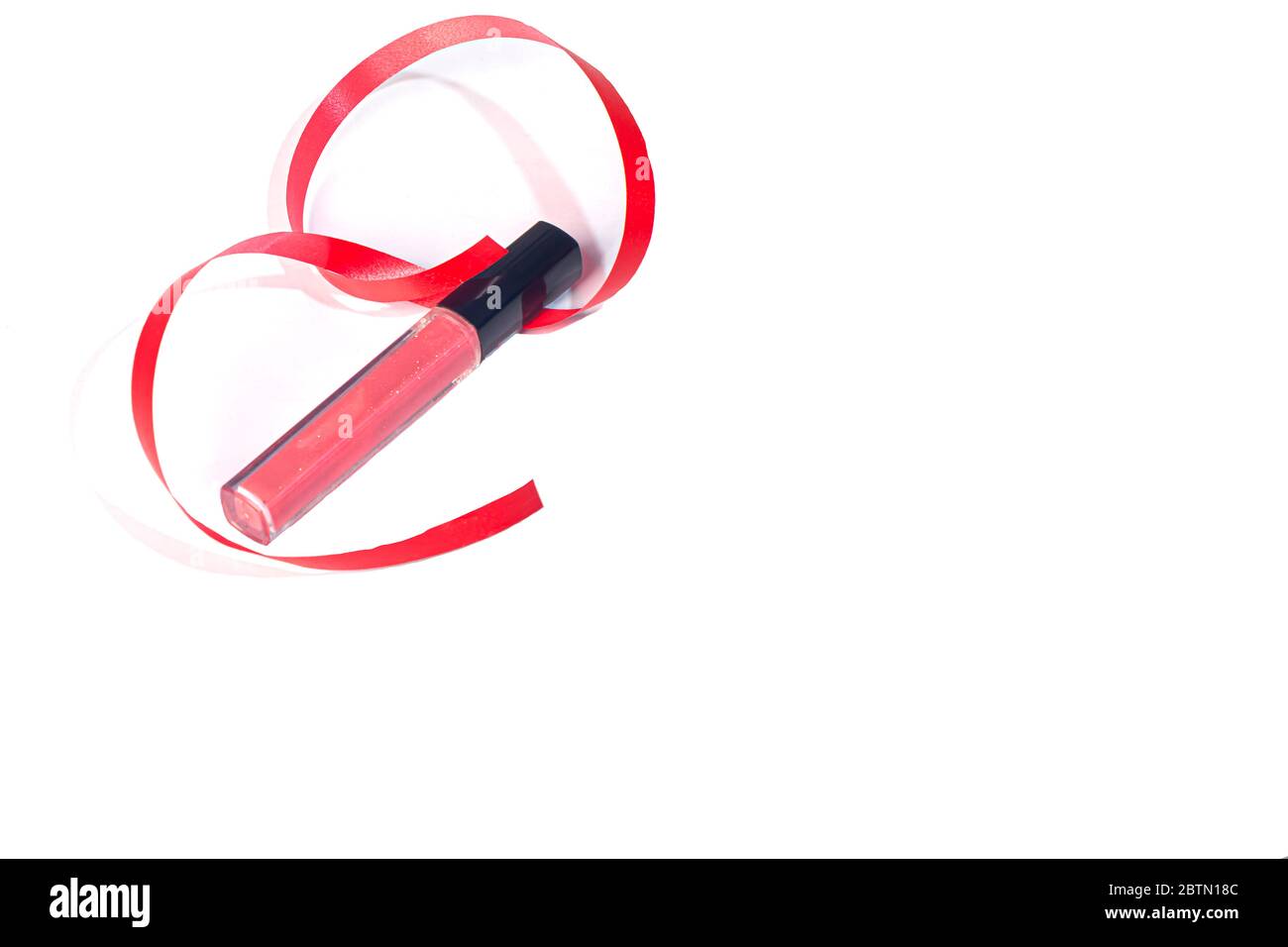 Rosa Lipgloss auf weißem Hintergrund mit einem roten Band. Isolieren Stockfoto