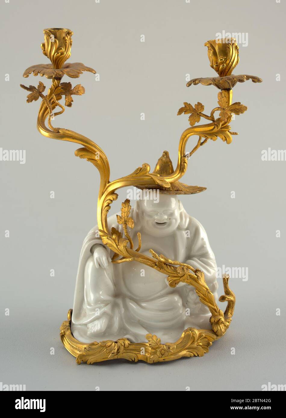 Ein Paar TwoLight Candelabra. Forschung in ProgressSeated Figur ("Lachender buddha") in glasierten weißen Porzellan mit einem wirbelnden, belaubten, zweigegabelten ormolu Zweig endet in zwei Kerzendosen. Stockfoto