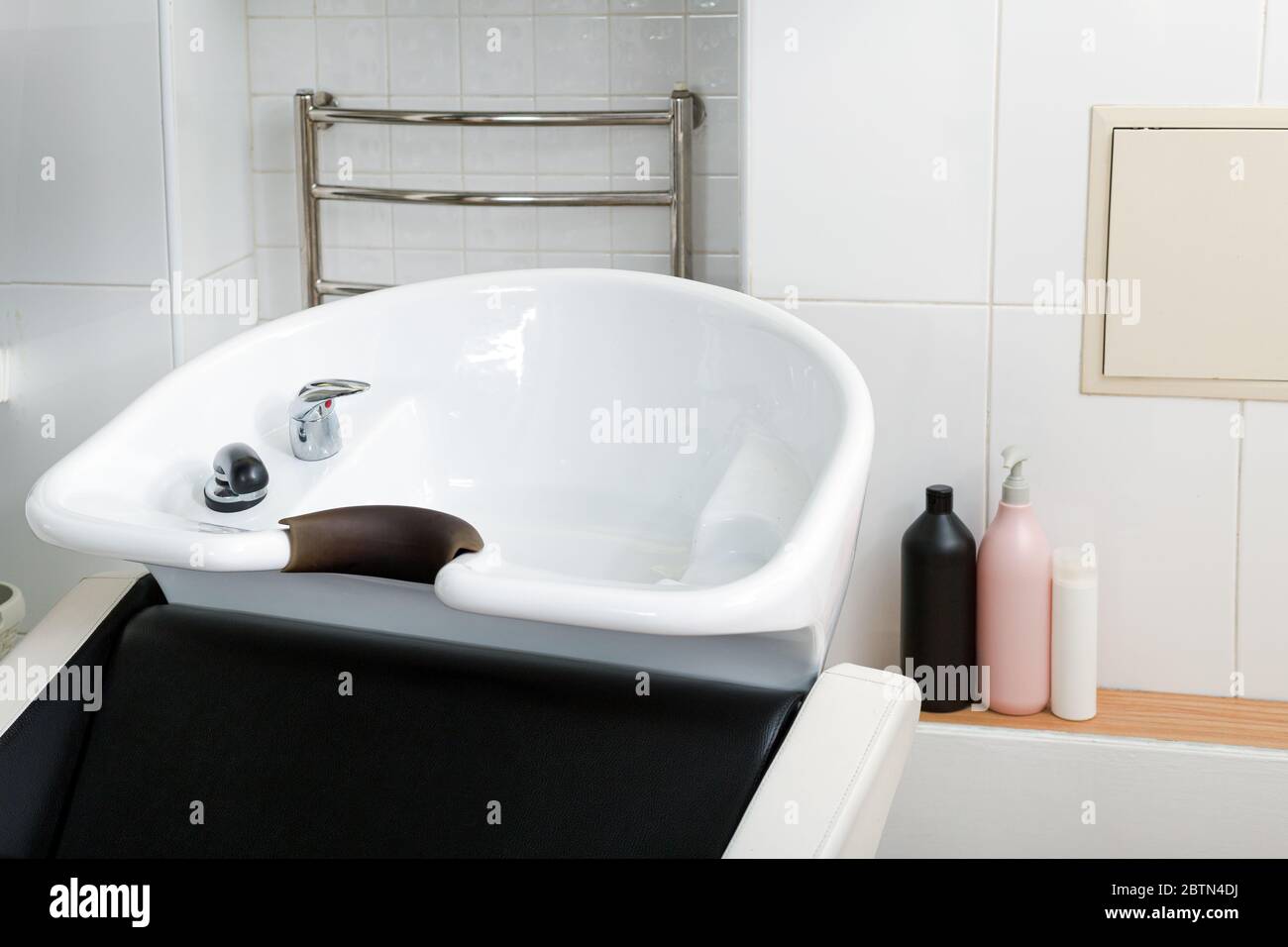 Haarwaschbecken zum Waschen der Haare im Schönheitssalon oder Friseur-Shop, Shampoos Haarkosmetik für Spa-Behandlung. Friseur Stylist Arbeitsplatz Stockfoto