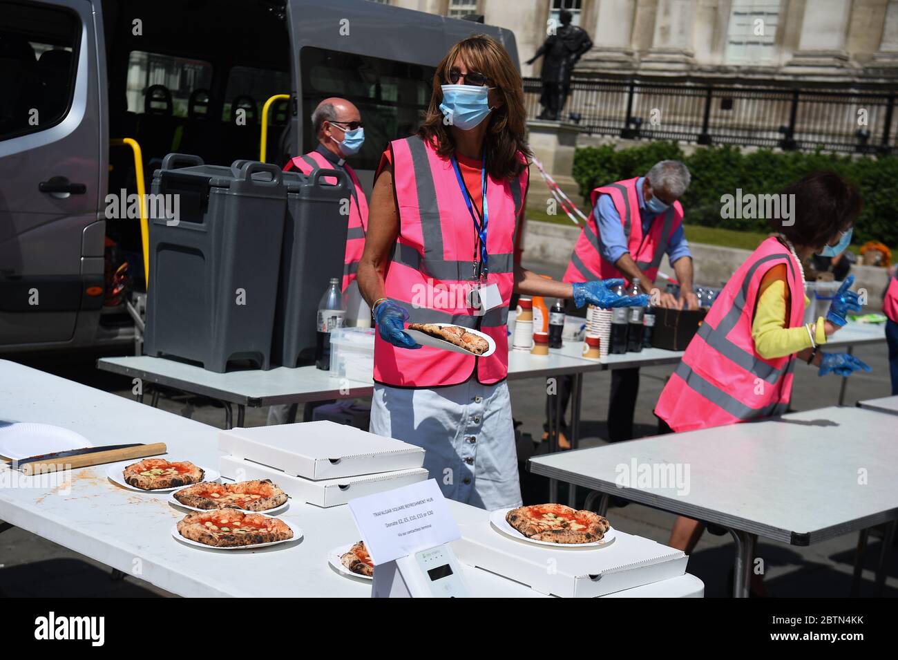 Pandemie-Pizzapersonal serviert Pizza im Trafalgar Square, London, wo Pandemie Pizza und Trafalgar Square Refreshment Hub zusammengetan haben, um Obdachlosen Erfrischungen zu bieten, nachdem Maßnahmen eingeführt wurden, um das Land aus der Blockierung zu bringen. Stockfoto