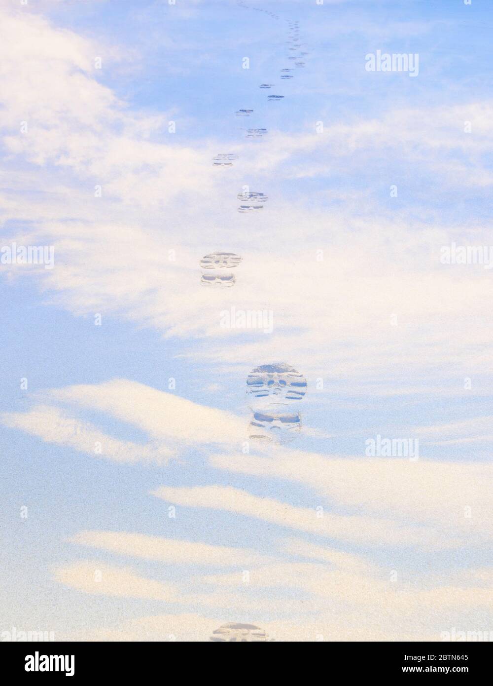 Skyscape mit Fußabdrücken Stiefelabdrücke über einem blauen Himmel. Reisekonzept in die unbekannte Zukunft Stockfoto