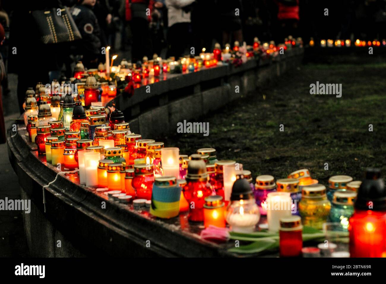 Menschenmenge zündet Kerzen im Stadtzentrum an, trauernde Opfer in Terroranschlägen und Revolutionen, Traurigkeit Moment Stockfoto