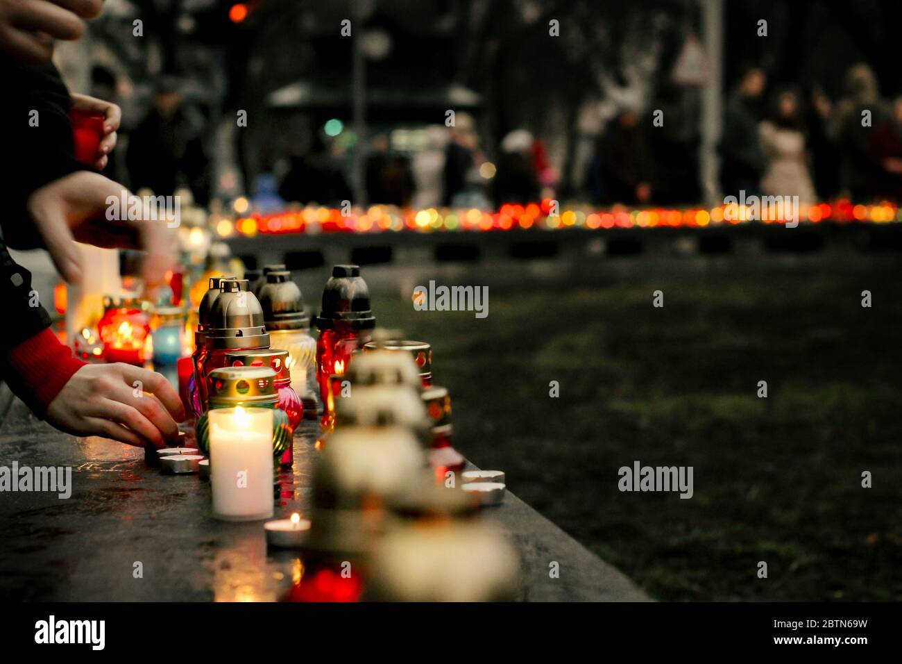 Menschenmenge zündet Kerzen im Stadtzentrum an, trauernde Opfer in Terroranschlägen und Revolutionen, Traurigkeit Moment Stockfoto