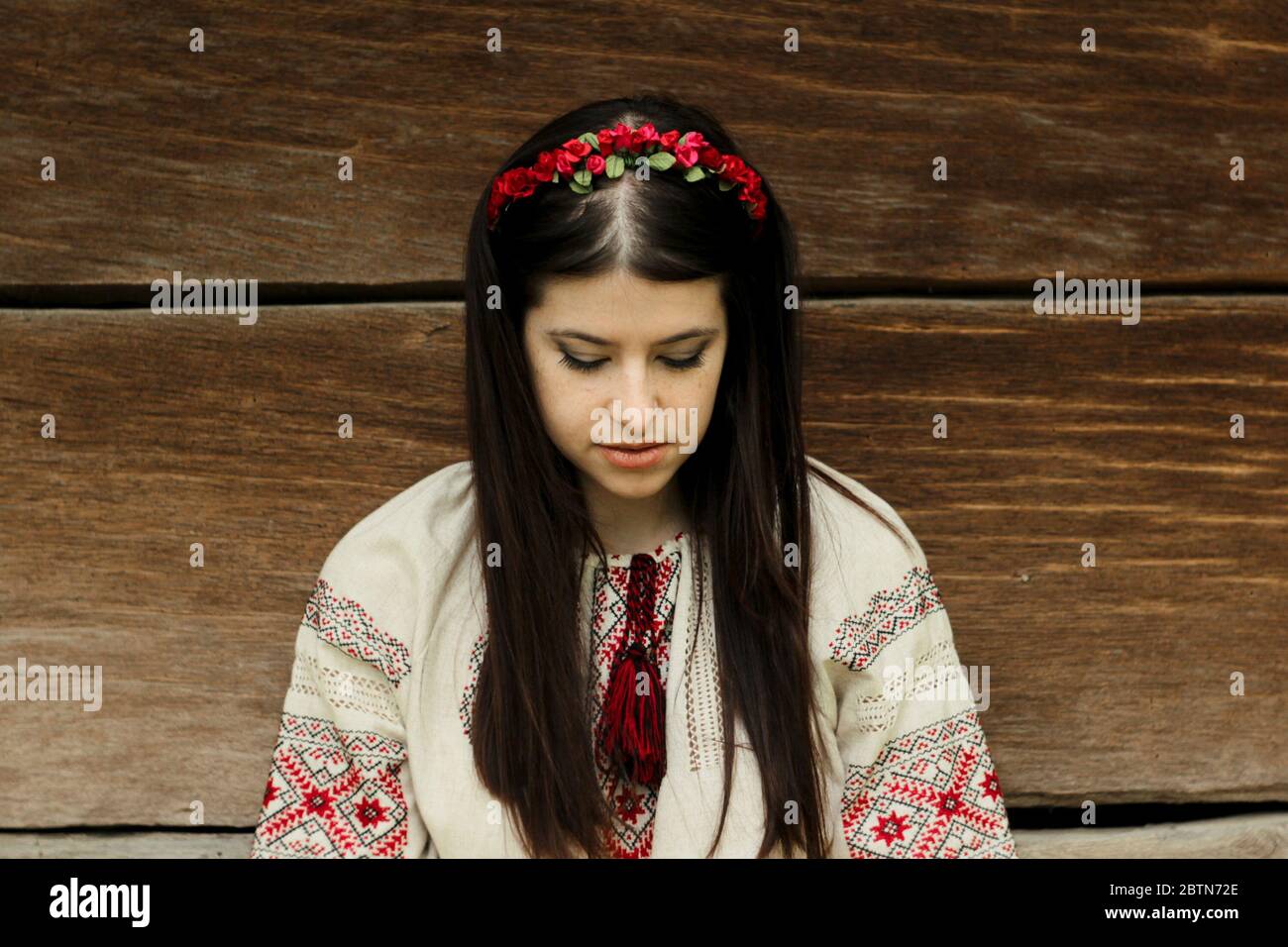 Schöne Brünette Frau in nationalen ukrainischen Stickerei Kleidung auf dem Hintergrund der alten einheimischen Holzhaus Stockfoto