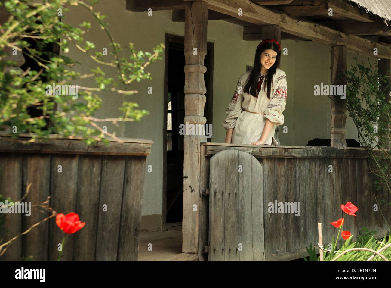 Schöne Brünette Frau in nationalen ukrainischen Stickerei Kleidung auf dem Hintergrund der alten einheimischen Holzhaus Stockfoto